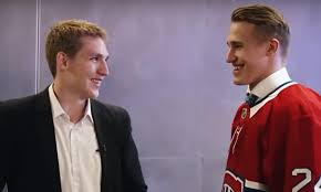 Lane Hutson and Ivan Demidov grinning at one another face to face