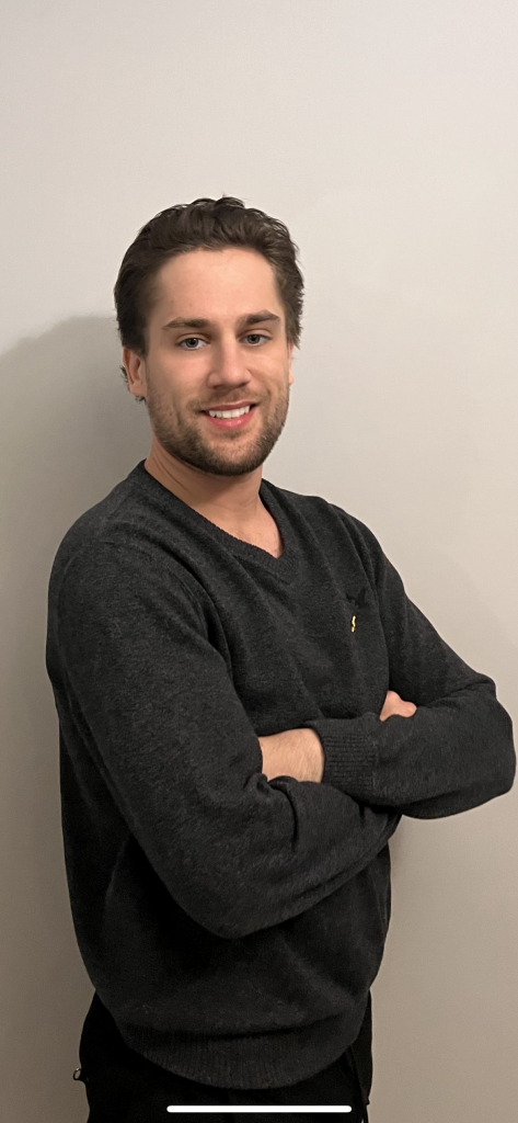 Tyler Dixon, creator of HabsInsider.com, smiling with arms crossed in a dark sweater